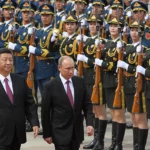 Russian President Vladimir Putin walks with Chinese President Xi Jinping