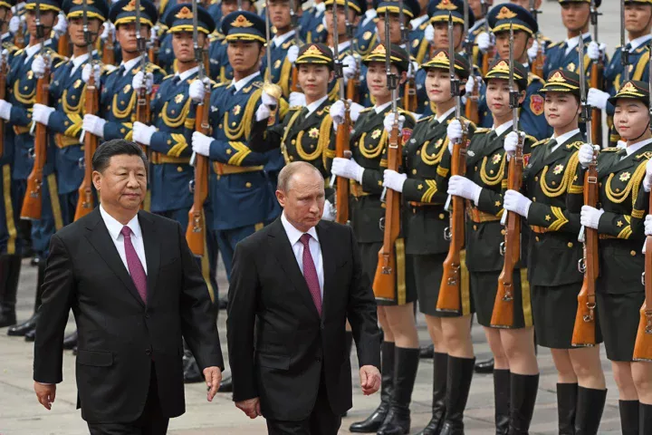 Russian President Vladimir Putin walks with Chinese President Xi Jinping