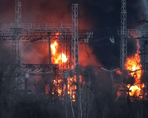 Smoke and fire are seen around high-voltage lines at a site of a Russian missile strike outside Kharkiv